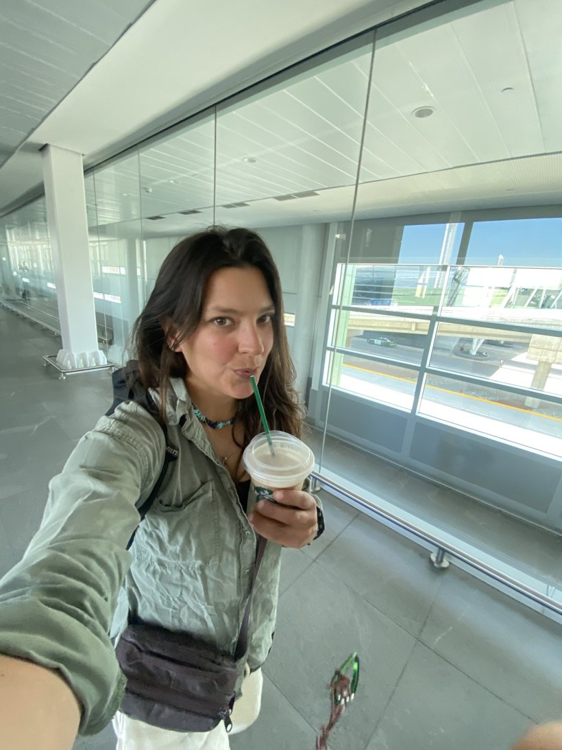 Mari en un aeropuerto, con un vaso en la mano